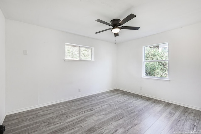 unfurnished room featuring hardwood / wood-style floors, ceiling fan, and a healthy amount of sunlight