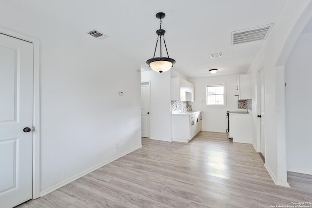 kitchen featuring tasteful backsplash, white cabinetry, light hardwood / wood-style flooring, and pendant lighting