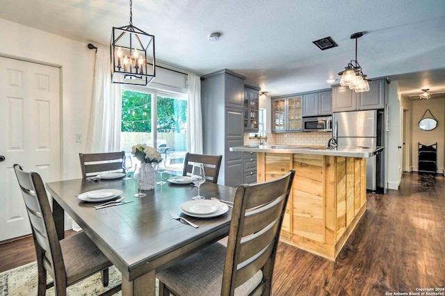 dining space with a chandelier and dark wood-type flooring