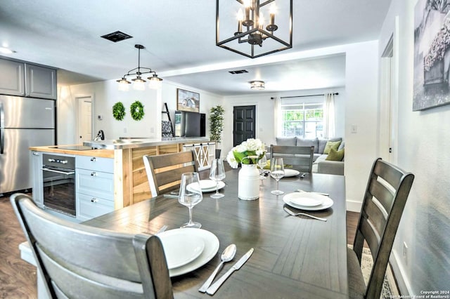 dining space with dark hardwood / wood-style flooring and a notable chandelier