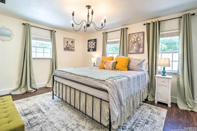 bedroom with dark hardwood / wood-style flooring and an inviting chandelier