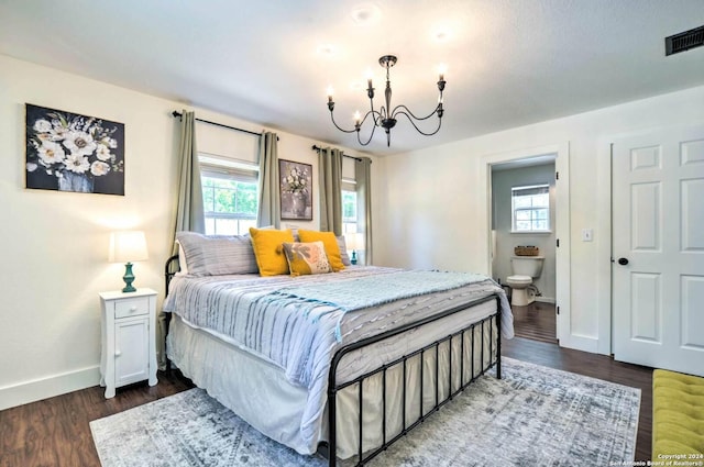 bedroom featuring a chandelier, dark hardwood / wood-style flooring, and connected bathroom