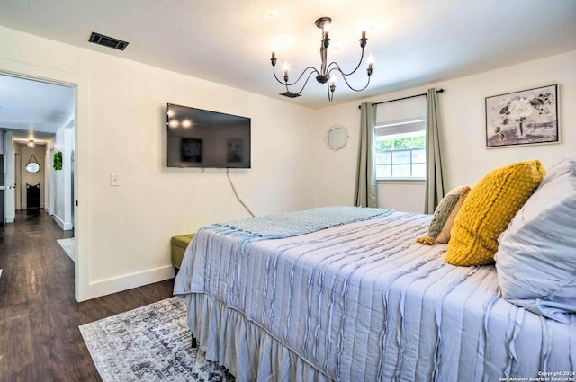 bedroom with dark hardwood / wood-style flooring and a chandelier