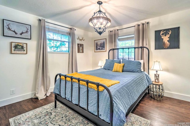 bedroom featuring dark hardwood / wood-style flooring and an inviting chandelier