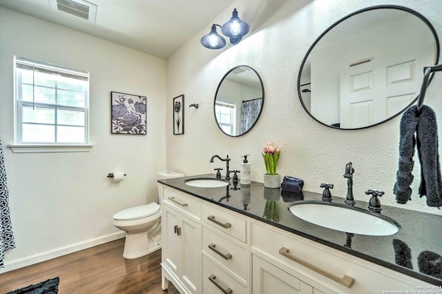 bathroom with hardwood / wood-style floors, vanity, and toilet