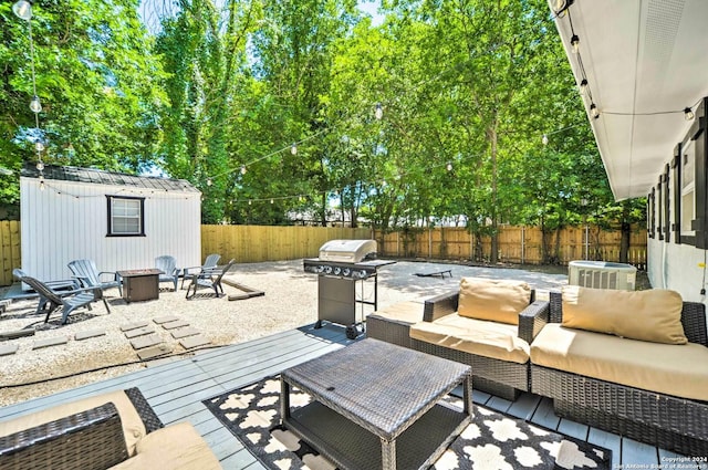 view of patio / terrace featuring cooling unit, area for grilling, a deck, and an outdoor living space with a fire pit