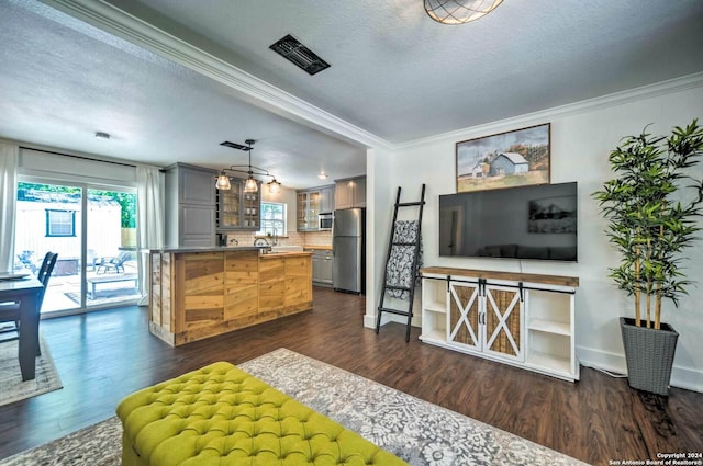 kitchen with stainless steel appliances, dark hardwood / wood-style floors, crown molding, a textured ceiling, and decorative backsplash