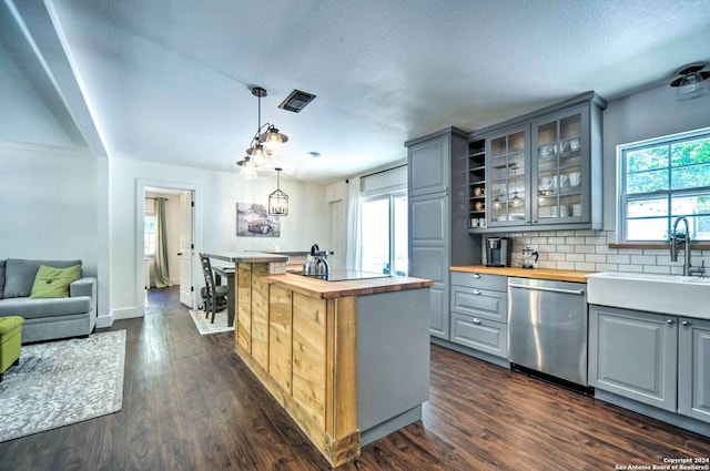 kitchen featuring sink, dark wood-type flooring, stainless steel dishwasher, butcher block countertops, and gray cabinets