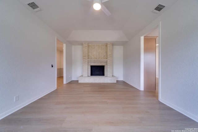 unfurnished living room with a fireplace, light wood-type flooring, and ceiling fan