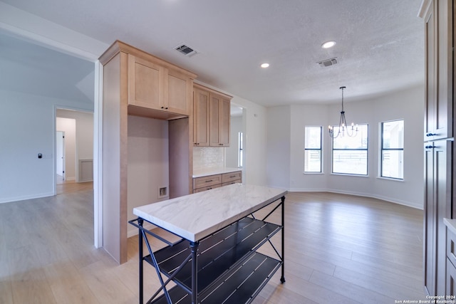 kitchen featuring a notable chandelier, pendant lighting, decorative backsplash, light brown cabinetry, and light wood-type flooring