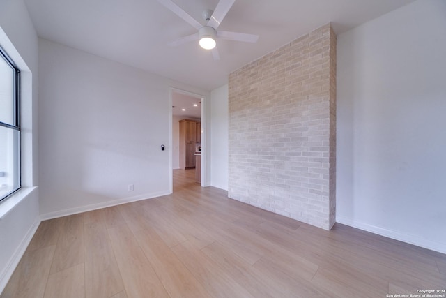 unfurnished room with light hardwood / wood-style flooring, ceiling fan, and a healthy amount of sunlight