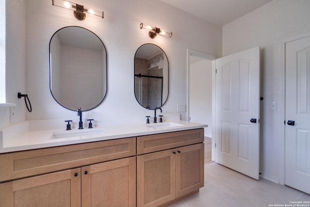 bathroom featuring tile patterned floors, a shower with door, and vanity