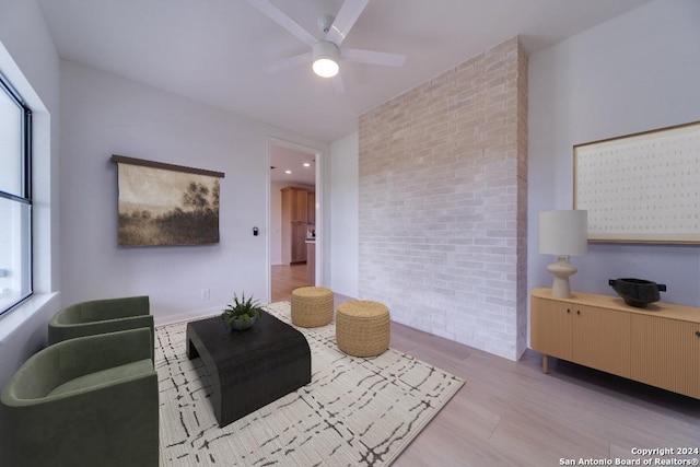 living room with ceiling fan, light wood-type flooring, and a wealth of natural light