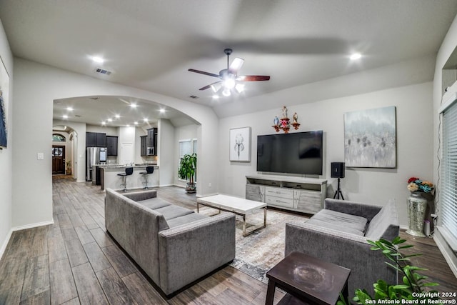 living room featuring ceiling fan, plenty of natural light, and dark hardwood / wood-style floors