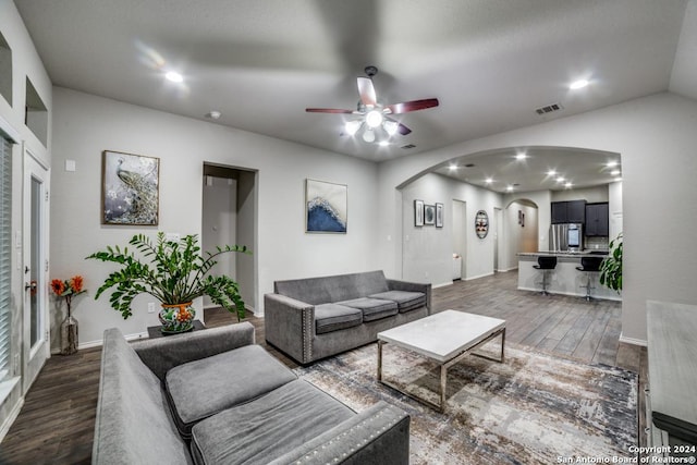 living room featuring ceiling fan, dark wood-type flooring, and vaulted ceiling