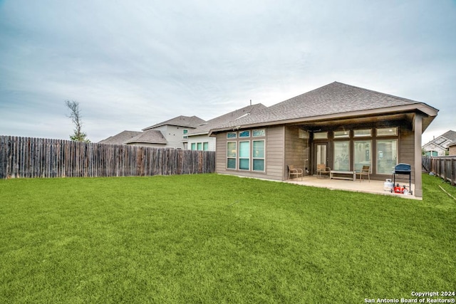 back of property with a lawn and a patio