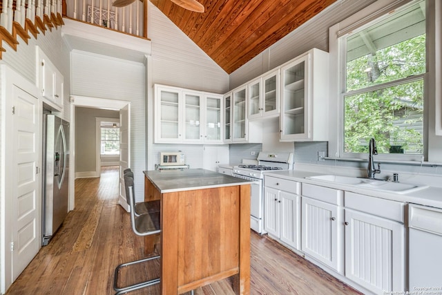 kitchen with a center island, white appliances, white cabinets, sink, and light hardwood / wood-style flooring