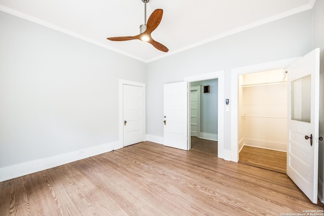 unfurnished bedroom featuring ceiling fan, a closet, ornamental molding, and light hardwood / wood-style flooring