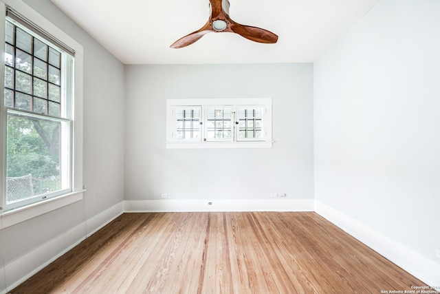 spare room with hardwood / wood-style floors, ceiling fan, and a healthy amount of sunlight