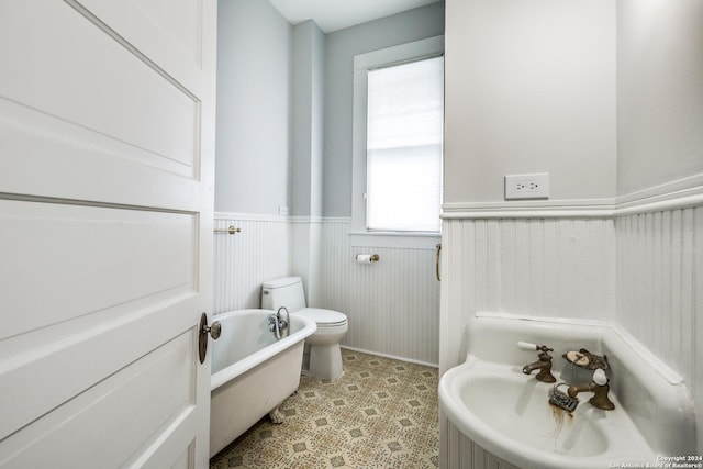 bathroom featuring toilet and a tub to relax in