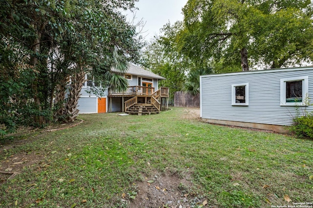 view of yard featuring a garage and a wooden deck