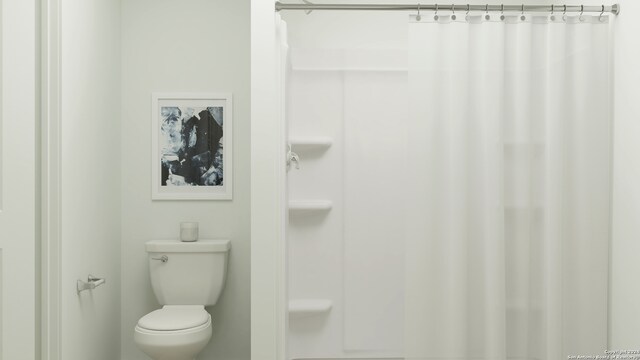 bathroom featuring a shower with shower curtain and toilet