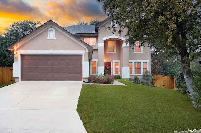 view of front of property with a garage and a lawn