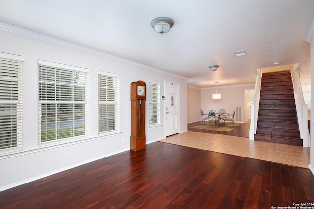 foyer entrance with hardwood / wood-style flooring and crown molding