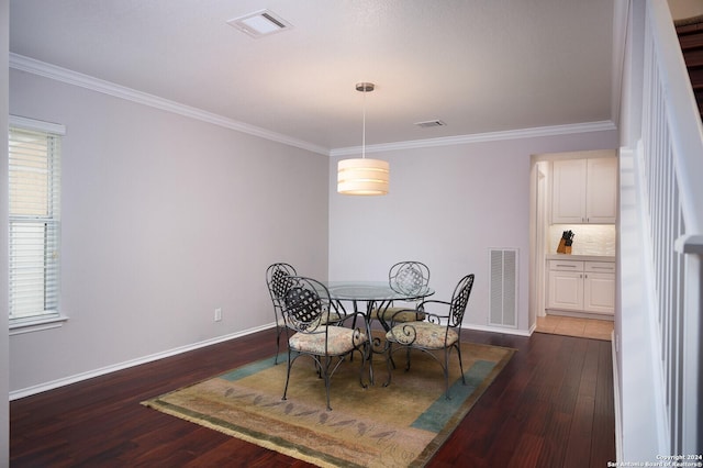 dining room featuring dark hardwood / wood-style flooring and crown molding