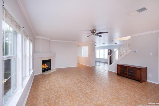 unfurnished living room with ceiling fan, a fireplace, light tile patterned floors, and ornamental molding