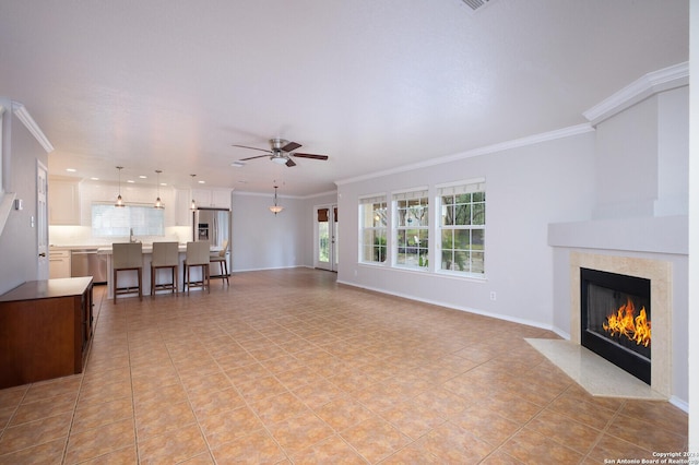 living room featuring ceiling fan, light tile patterned floors, ornamental molding, and a high end fireplace