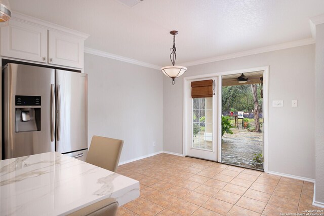 kitchen with white cabinetry, stainless steel fridge with ice dispenser, light stone counters, pendant lighting, and light tile patterned floors