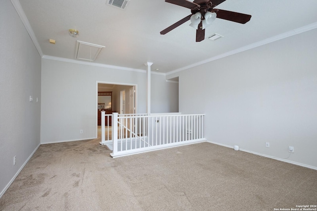 carpeted spare room with ceiling fan and ornamental molding