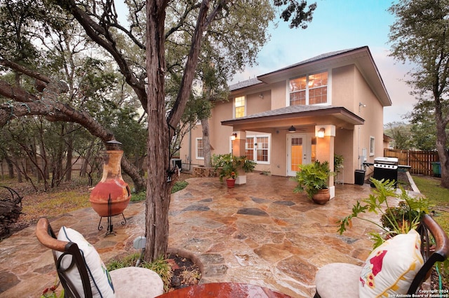 back of property featuring ceiling fan and a patio area