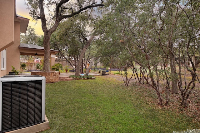 yard at dusk featuring central AC unit