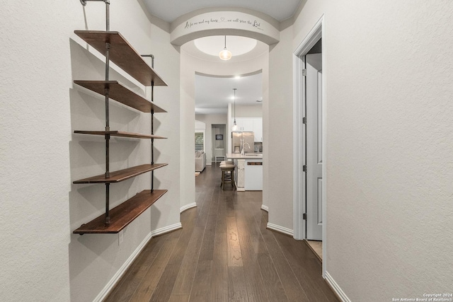 hallway featuring sink and dark wood-type flooring