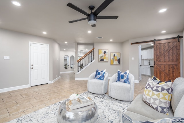 tiled living room with a barn door and ceiling fan