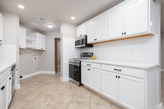 kitchen featuring decorative backsplash, light stone counters, stainless steel appliances, white cabinets, and light tile patterned flooring