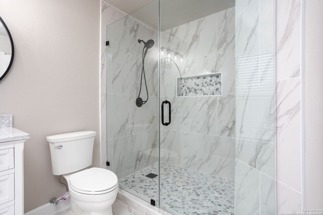 bathroom featuring vanity, toilet, and a shower with shower door