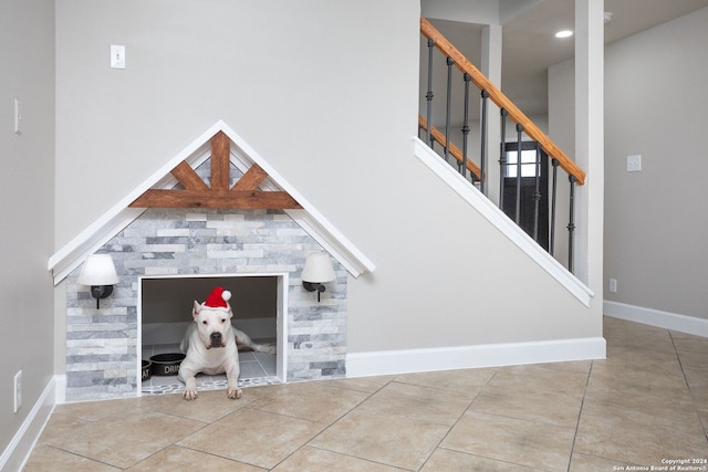 stairway featuring tile patterned flooring and a towering ceiling