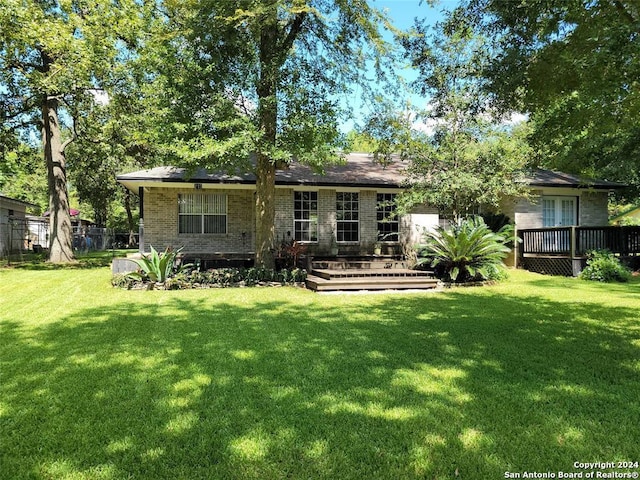 back of house featuring a lawn and a deck