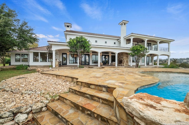 rear view of property with a balcony and a patio