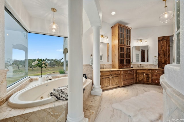 bathroom with vanity, tiled tub, and decorative columns