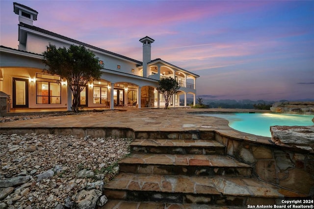 view of pool at dusk