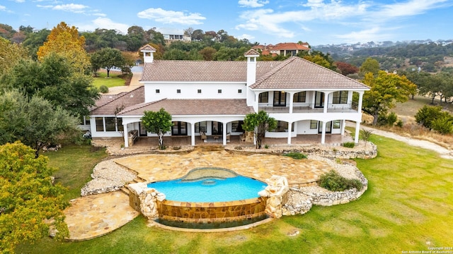 back of house with a lawn, a balcony, and a patio