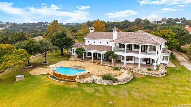 back of property featuring a yard and a balcony