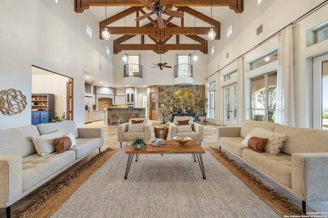 living room featuring hardwood / wood-style flooring, a healthy amount of sunlight, beam ceiling, and high vaulted ceiling