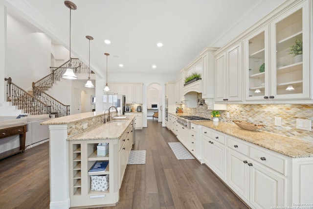 kitchen with a spacious island, decorative backsplash, hanging light fixtures, and dark wood-type flooring