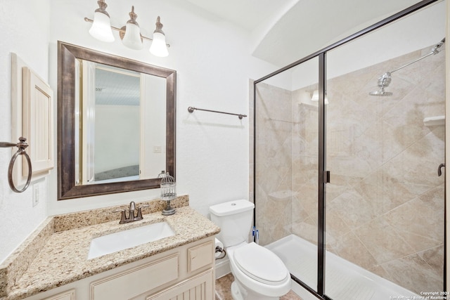 bathroom featuring vanity, toilet, and a shower with shower door