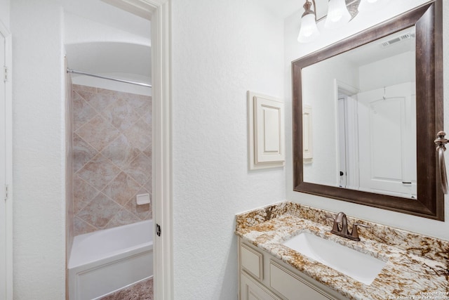 bathroom with vanity and tiled shower / bath combo